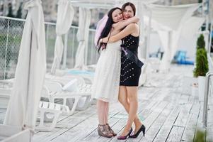 Two girls posed at hen party on the pier of beach. photo