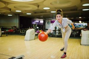 Girl with bowling ball on alley played at bowling club. photo