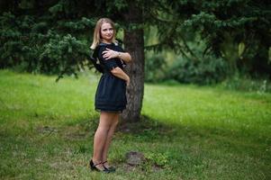 Portrait of gorgeous girl wear on black at hen party, posed at park. photo