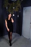 Cute girl wear on black dress against christmas decoration. photo