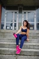 Young beautiful woman doing exercises outdoor, training process. photo