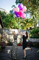 dos chicas visten de negro con globos en la despedida de soltera. foto