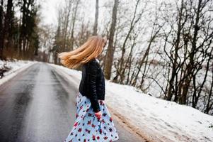Stylish girl in leather jacket at winter day on road. photo