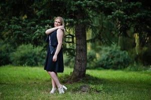 Portrait of gorgeous girl wear on black at hen party, posed at park. photo