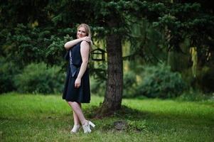 Portrait of gorgeous girl wear on black at hen party, posed at park. photo