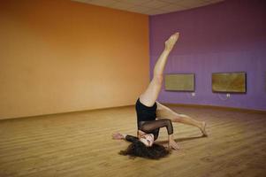 Curly brunette plus size model doing acrobatic at dance room. photo