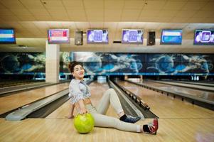 chica con bola de bolos en el callejón jugado en el club de bolos. foto