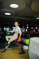 chica con bola de bolos en el callejón jugado en el club de bolos. foto