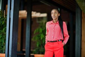 Pretty braids business african american lady bright bossy person friendly wear office red shirt and trousers. photo