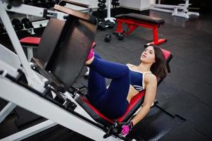 Young beautiful woman doing exercises  and working hard in gym and enjoying her training process. photo