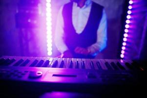 Hand of keyboardist on stage with lights. photo