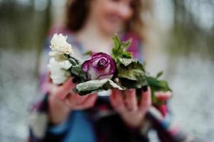 Ggirl holding wreath on hands at snowy forest in winter day. photo