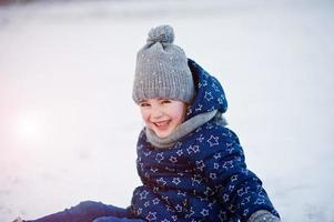 linda niña con trineos de platillos al aire libre en el día de invierno. foto