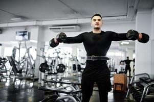Muscular arab man training with dumbbells in modern gym. photo