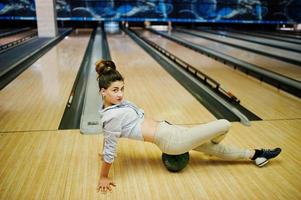 chica con bola de bolos en el callejón jugado en el club de bolos. foto