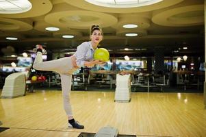 Girl with bowling ball on alley played at bowling club. photo