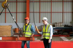 dos jóvenes ingenieros probando y comprobando el funcionamiento de la grúa semi pórtico foto