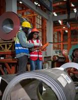 dos técnicos inspeccionando y probando el funcionamiento de grúas elevadoras en plantas industriales pesadas. foto