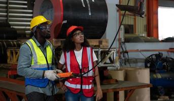 Two technicians Inspecting and testing the operation of lifting cranes in heavy industrial plants. photo