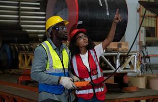 Two technicians Inspecting and testing the operation of lifting cranes in heavy industrial plants. photo