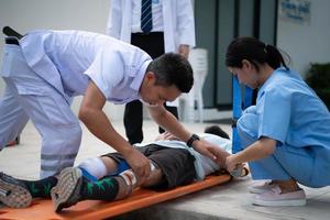 First aid assistance of the ambulance medical team with CPR method and hand-squeezed breathing apparatus photo