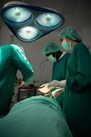 Professor of medicine in cardiology and a team of doctors in the operating room undergoing heart transplant surgery photo