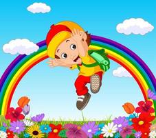 chico lindo en un jardín de flores con arco iris vector