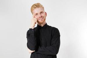 portrait of handsome red-haired guy on black, hipster posing isolated on white, Isolated studio shot of young handsome redhead hipster man looking happy friendly and pensive at camera. photo