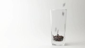 cámara lenta de verter los granos de café tostados en el vaso. video