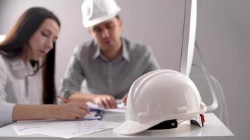 dos ingenieros trabajando en el proyecto. dos ingenieros trabajando en un proyecto en el trabajo. uno es hembra y el otro es macho. video