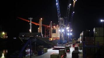 nattdriftstrafik i hamnen. containrar lastade ombord. nattarbetare. nattskift. import och export. video