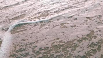 Close Up Wave Sand Beach Sea Foam.  Closeup of sea wave with foam on beach sand. Vacation Summer background