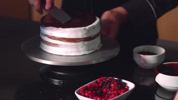 fazendo bolo de frutas e chocolate. vídeo acelerado. o mestre pasteleiro está a fazer um bolo com as suas mãos hábeis. video
