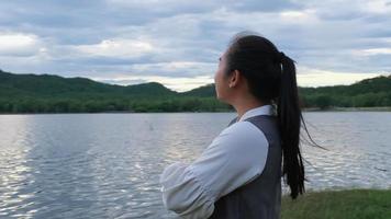 femme asiatique profitant de la vue sur la nature au bord du lac au coucher du soleil. concept de style de vie et de voyage de vacances video