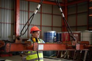 dos jóvenes ingenieros probando y comprobando el funcionamiento de la grúa semi pórtico foto