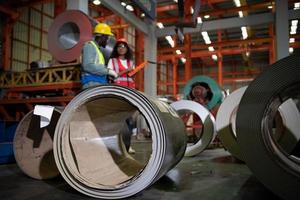 dos técnicos inspeccionando y probando el funcionamiento de grúas elevadoras en plantas industriales pesadas. foto