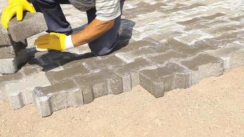 Worker laying cobblestone. Gray color keystone road floor background. Working worker. Worker laying keystone with his hands. video