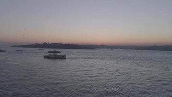 trafic maritime d'istanbul au coucher du soleil. vue sur la ville d'istanbul au coucher du soleil. mouettes volant dans la mer.