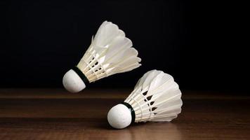 slow motion badminton ball falling on black background, indoor sport concept video