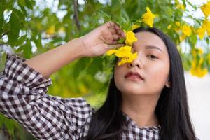 retrato joven con flores amarillas, chica asiática. foto