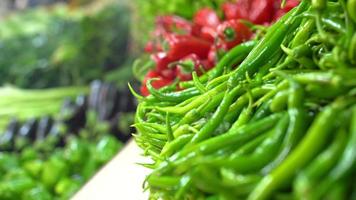 rode en groene paprika. rode en groene pepers beschikbaar op het aanrecht. video