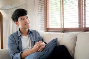 Portrait young handsome asian man napping relax with cozy on sofa at home, asia male resting and sleeping in weekend with tired and lazy on couch in vacation, lifestyle and wellbeing concept. photo