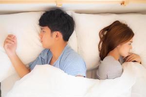 Young asian couple lying separate and failure on bed at home, asia family having problem conflict and divorce, man and woman unhappy and stress with relationship, lifestyle concept, top view. photo