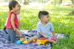 Little boy and girl is playing for idea and inspiration with toy block, kid learning with construction block for education, child activity and game in the park with happy in the summer. photo