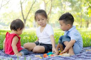 el niño y la niña están jugando por ideas e inspiración con bloques de juguete, niños aprendiendo con bloques de construcción para la educación, actividades infantiles y juegos en el parque con felicidad en el verano. foto