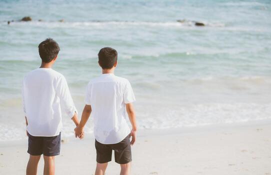 Asian gay couple holding hands together on the beach with relax and leisure in summer, LGBT homosexual legal two man happy and romantic in vacation, relationship sex lover concept. photo