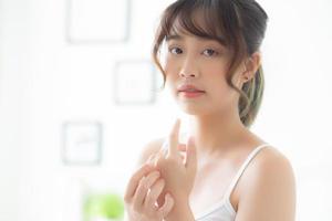 Young asian woman applying cream and treatment for skin care touch on hand, asia girl with lotion spa and moisturizing for health and wellness body part, lifestyle and beauty cosmetic concept. photo