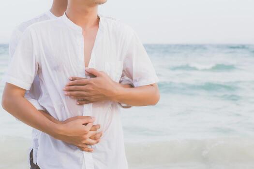 Homosexual portrait young asian couple standing hug and look together on beach in summer, asia gay going tourism for leisure and relax with romantic and happy in vacation at sea, LGBT legal concept. photo
