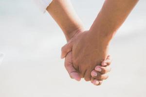 Closeup asian gay couple holding hands together on the beach with relax and leisure in summer, LGBT homosexual legal two man happy and romantic in vacation, relationship sex lover concept. photo