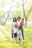 Beautiful young asian parent family portrait picnic in the park, kid or children and mother love happy and cheerful together in summer at garden, lifestyle concept. photo